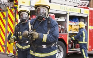 Firefighters in full gear ready to fight a fire.