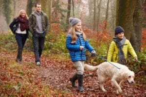 Family in the woods with their neutered dog.
